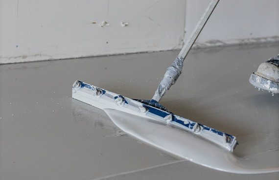 Concrete floor being prepared with self levelling compound prior to receiving epoxy floor coating.